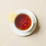 Williamson Earl Grey, 50 Tea Bags 125g, top view of tea brewing in white cup with lemon slice on the saucer, available at teas.co.uk
