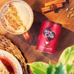 Drink Me Chai Spiced Chai Latte, 250g, jar on table with latte lifestyle, available at teas.co.uk