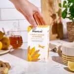Dragonfly Organic Lively Lemon and Ginger, 20 Tea Bags 34g, box on tabel with brewing mug of tea, available at teas.co.uk