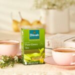 Dilmah Ceylon Pure Green Loose Leaf Tea, 100g, lifestyle box next to tea brewing, available at teas.co.uk