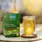 Dilmah Ceylon Pure Green Loose Leaf Tea, 100g, lifestyle tea box with tea brewing in clear mug, available at teas.co.uk