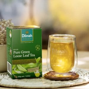 Dilmah Ceylon Pure Green Loose Leaf Tea, 100g, lifestyle tea box with tea brewing in clear mug, available at teas.co.uk